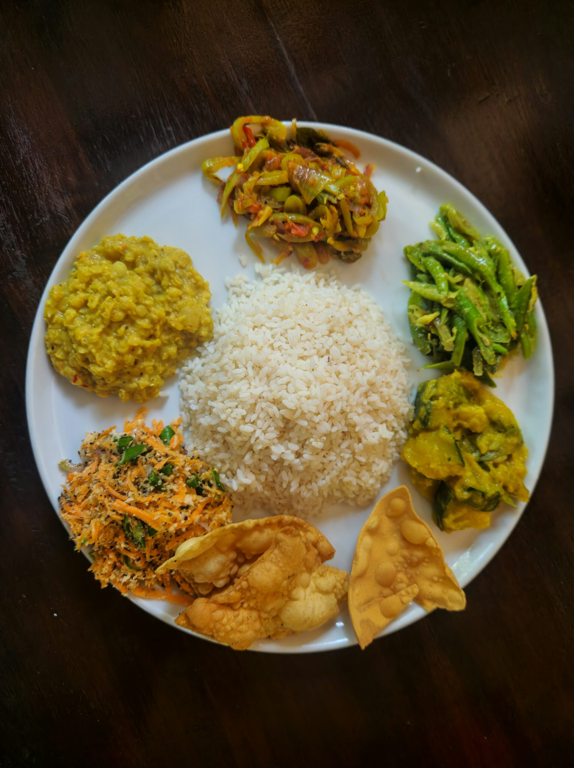 Hands preparing fresh vegetables and grated coconut for a Sri Lankan curry